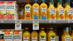 Prateleiras com sucos de laranja em supermercado americano