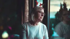 Older lady looking out of a window