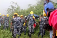 एअर डाइनेस्टीको हेलिकप्टर दुर्घटनामा परेर ज्यान गुमाएका मानिसको शव बोक्दै सुरक्षाकर्मीहरू