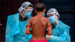 Ребенок перед двумя медработниками