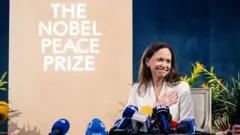 María Corina Machado por trás de microfones, com um cartaz do Prêmio Nobel da Paz ao fundo