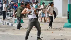 A protester wields a firearm as demonstrators gather outside the Singha Durbar palace complex during a protest to condemn the police's deadly crackdown on demonstrators in Kathmandu on September 9, 2025