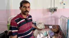 تالا على سرير في مستشفى وبجانبها والدها