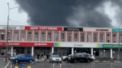 Colunas de fumaça atrás de dois edifícios russos.