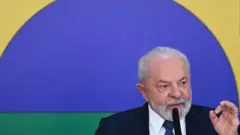 Lula gesticulandovaidebet liga nao encontradafrente a painel com cores do Brasil