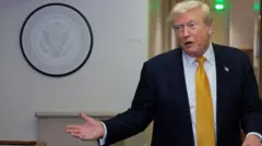 Donald Tramp u tamnom odelu sa žutom kravatom