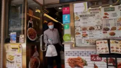 Un homme reçoit un plat à emporter d'un restaurant de Hong Kong