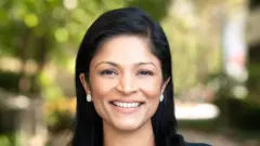 Aparna Bawa sorri para foto em área verde
