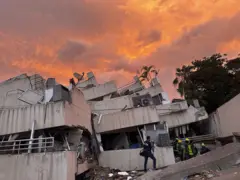 Residencias Vistamar con un atardecer intenso, frente a playa El Yate, Caraballeda. Se ven rescatistas trabajando.