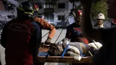 वेनेजुएला की राजधानी कराकास में भूकंप के बाद के शुरूआती घंटों में दमकल और सिविल प्रोटेक्शन के कर्मियों ने मलबे से एक बुज़ुर्ग व्यक्ति को ज़िंदा निकाला 