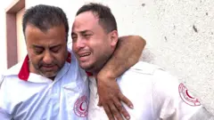 Mahmoud Al-Masry ditenangkan oleh rekannya setelah ayahnya terbunuh, 11 Oktober 2023