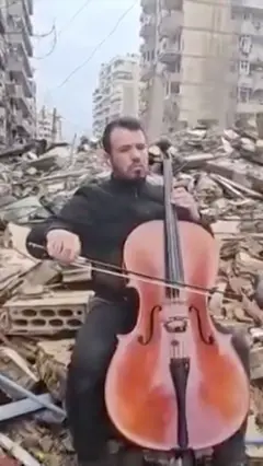 Muškarac svira čelo na ruševinama