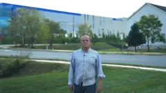Gregory Pillio stands in front of a data center near his home in Loudoun County.