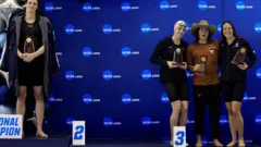 A nadadora transgênero Lia Thomas da Universidade da Pensilvânia fica no pódio depois de vencer o estilo livre de 500 jardas enquanto outras medalhistas Emma Weyant, Erica Sullivan e Brooke Forde posam para uma foto na NCAA Division I Women's Swimming & Diving Campeonato em 17 de março de 2022 em Atlanta, Geórgia.