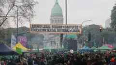 Uma faixa com os dizeres "Aborto Legal, Seguro e Gratuito" é vista enquanto ativistas se reúnem em frente ao prédio do Congresso Nacional durante a votação dos senadores pela nova lei do aborto, em Buenos Aires, Argentina