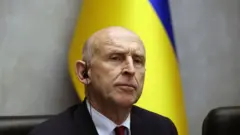министр обороны Великобритании Джон Хили на фоне флага Украины 