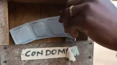 Une main prenant des préservatifs
