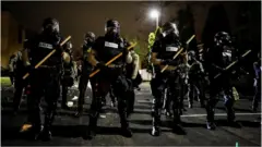 Officers stand guard outside Brooklyn Center Police Department