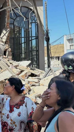Mujer mira con asombro cómo se derrumbó una edificación