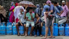 Watu wakiwa kwenye foleni kununua mitungi ya gesi ya kupikia nyumbani karibu na ghala la kuuza huku kukiwa na uhaba wa gesi ya kupikia huko Colombo, Sri Lanka, 02 Juni 2022.