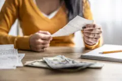 Mujer con dinero y cuentas en una mesa