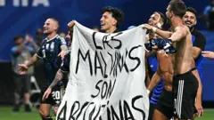 Jugadores de Argentina sostienen una pancarta con el mensaje "Las Malvinas (islas Falkland) pertenecen a Argentina" tras ganar el partido de semifinales del Mundial de fútbol