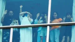 နိုင်ငံရွှေ့ပြောင်းအခြေချသူတွေ ဒီကယ်ပိုလစ် ဟိုတယ်ထဲကနေ အပြင်က လူတွေ အာရုံစိုက်မိအောင် ကြိုးစားနေ