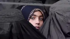 El afiche lee: No somos lo que otras personas nos definen. Tenemos nuestra propia identidad. Llámame por mi nombre. Yo estoy con WhereIsMyName? Estoy con Laleh Osmany (la mujer en la foto).