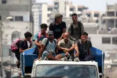 Hombres palestinos viajan en una camioneta de transporte público en la Ciudad de Gaza el 8 de agosto de 2025.