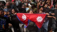 भदौ २४ गते संसद् भवन परिसरमा नेपालको झण्डा लिएर उभिएका युवाहरू