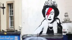 O mural de Banksy em Bristol, na Inglaterra, mostra a rainha Elizabeth 2ª vestida como na capa do álbum Aladdin Sane, de David Bowie, em homenagem afetuosa