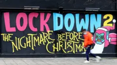 رجل يمر بجوار لوحة جدارية كتب عليها: "الإغلاق رقم 2 الكابوس قبل الكريسماس.