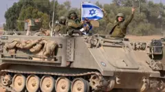 Soldados em veículo militar israelense levantam bandeira de Israel