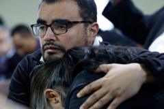 Dos personas se abrazan en una vigilia por las familias de los desaparecidos en el accidente de Baltimore.