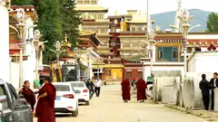 Monges e outras pessoas em uma estrada que leva ao mosteiro de Kirti