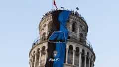 آویخته شدن بنر باشگاه پیزا از برج معروف شهر پس از صعود به دسته بالاتر