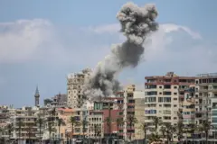 مبانٍ سكنية يتصاعد من بينها الدخان، بعد استهداف إسرائيلي لإحدى المناطق في مدينة صور، جنوبي لبنان.