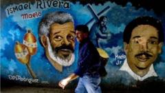 Un hombre pasa junto a un mural en el barrio caraqueño de Petare. 