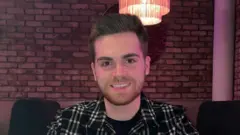 Um jovem sorridente com uma camisa xadrez