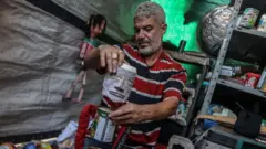 Mahdy Krira avec l'une de ses marionnettes en boîtes de conserve.