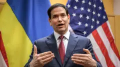  Госсекретарь США Марко Рубио жестикулирует на фоне флагов США и Украины