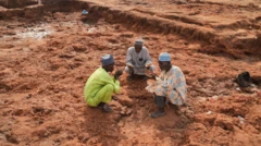 Group of men dey pray for those wey die for wia pesin house dey before. Dem bend down.
