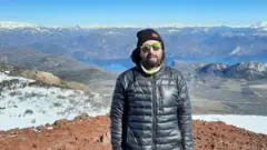 Hombre con gafas de sol y casaca en una montaña en la Patagonia argentina.