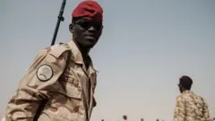 أحد أفراد قوات الدعم السريع يؤمّن المكان قبيل تجمعٍ لمؤيدي المجلس العسكري الانتقالي الحاكم في قرية أبْرَق، على بُعد نحو 60 كيلومتراً شمال غربي الخرطوم، في 22 يونيو/ حزيران 2019 