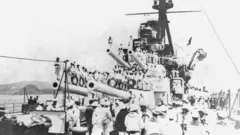 Imagem de navios de guerra e vários tripulantes