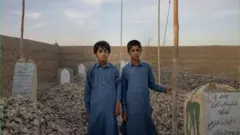 عمران و بلال در کنار قبر مادرشان