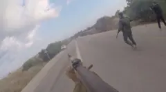Fotograma de un video en el que militantes de Hamás apuntan con un arma a un auto en la carretera