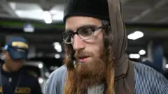 O cidadão israelense Yoel Alter, de 35 anos, membro da seita judaica ultraortodoxa Lev Tahor, escoltado por agentes da polícia guatemalteca, após ser detido em um tribunal da Cidade da Guatemala, no dia 24 de janeiro de 2025