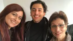 Gini y Anita de pie entre Christopher, quien tiene más de 20 años.