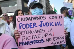 Manifestante segura um cartaz contra a reforma judicial. O cartaz diz: "Cidadãos com o Poder Judiciário. Paremos a ditadura. Ministros, vocês não estão sós".